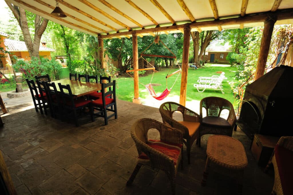 Covered terrace with dining table, hammock and garden at Melissa Wasi in Pisac