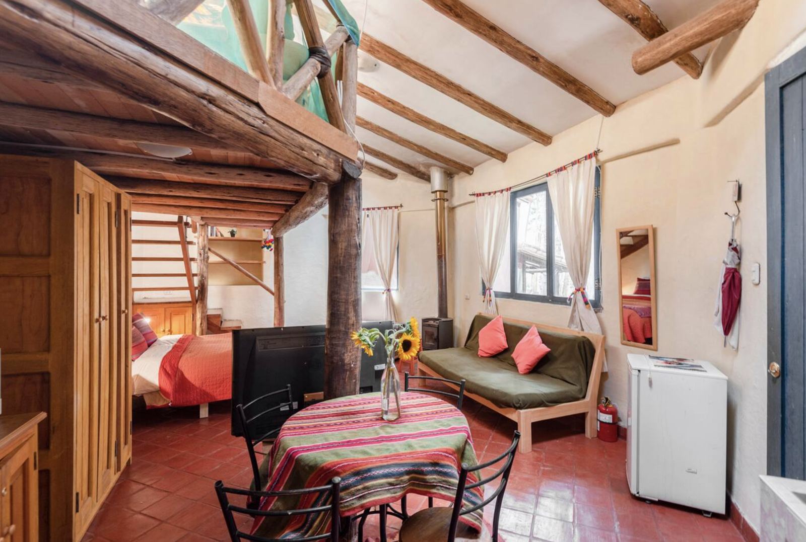 Bungalow sitting area with a sofa, a round table and sunflowers