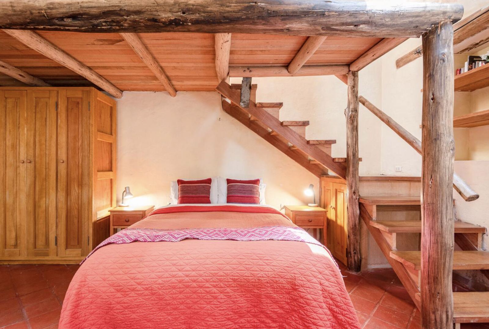 Wooden loft room with a double bed and a staircase
