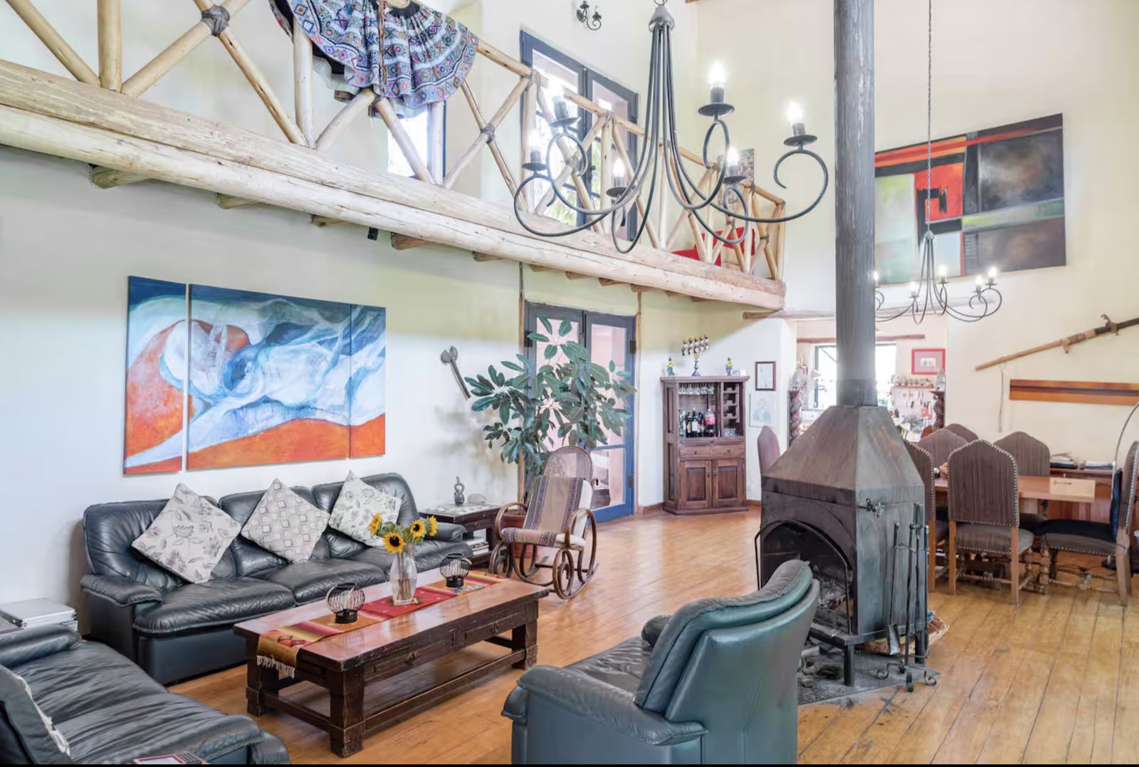 Lounge with leather sofas, a wood stove and colourful paintings