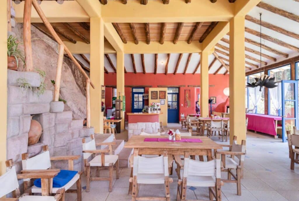 Dining hall with wooden beams and a stone staircase at Melissa Wasi in Pisac