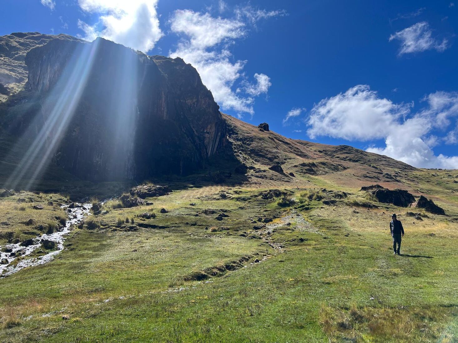 Sunlight over a high Andean valley with a lone walker